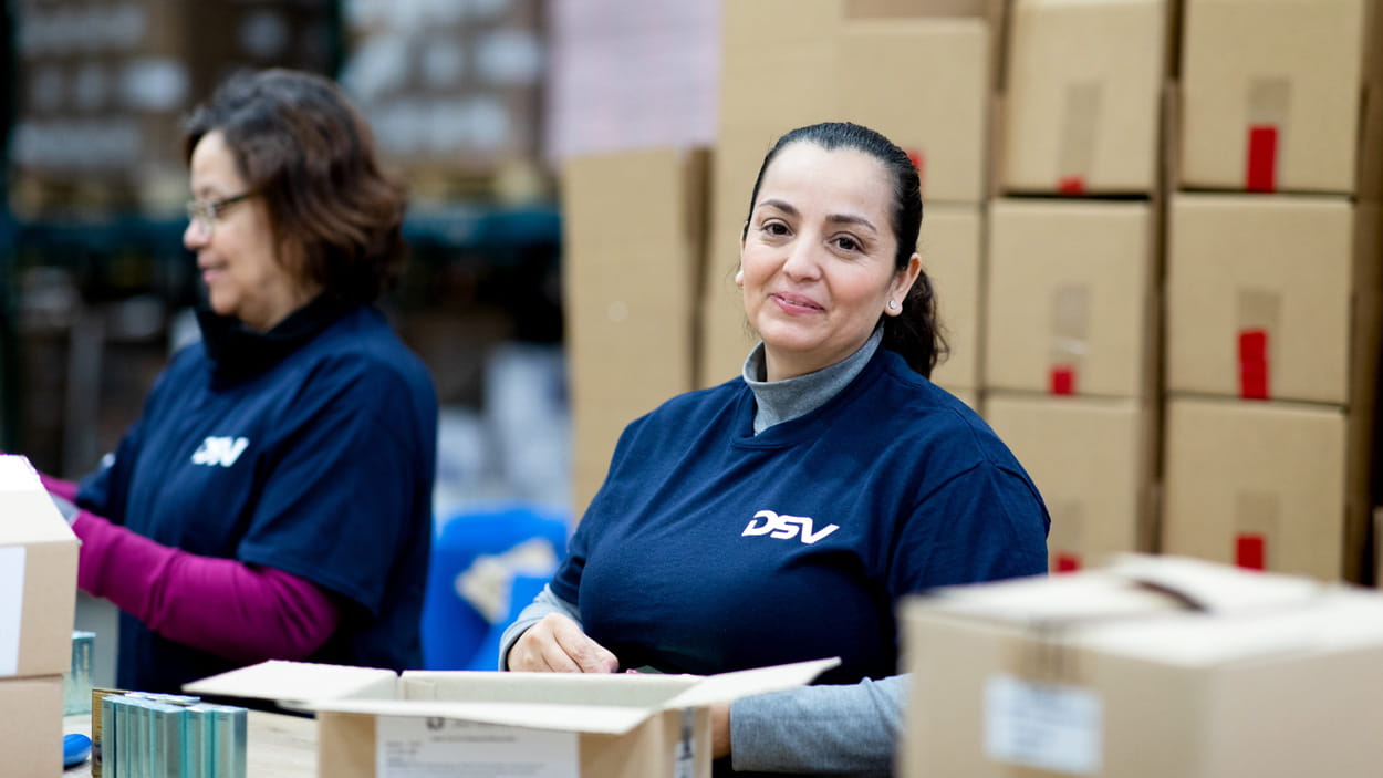 Two DSV team members working in a warehouse environment.